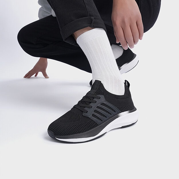 Benbild med svarta sneakers med vita detaljer