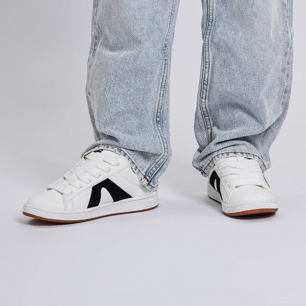 Vita sneakers matchade med gråa jeans