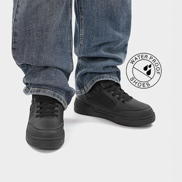 Svarta sneakers matchade med blåa jeans