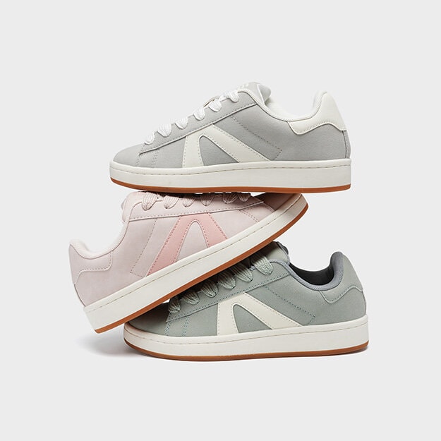 Tre skor staplade på varandra i pastelliga färger